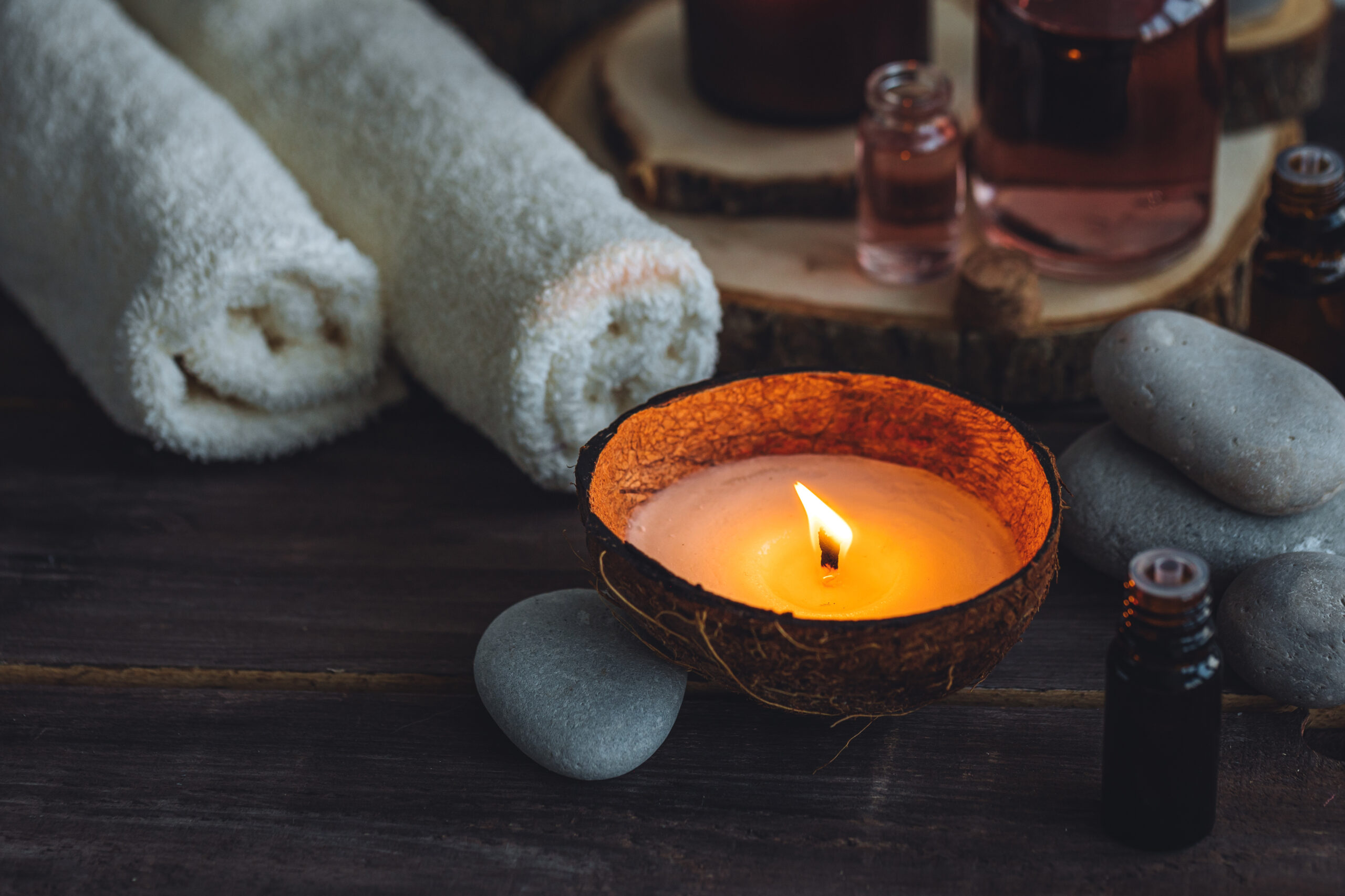 Concept of natural essential organic oils, Bali spa, beauty treatment, relax time. Atmosphere of relaxation, pleasure. Candles, towels, dark wooden background. Alternative oriental medicine